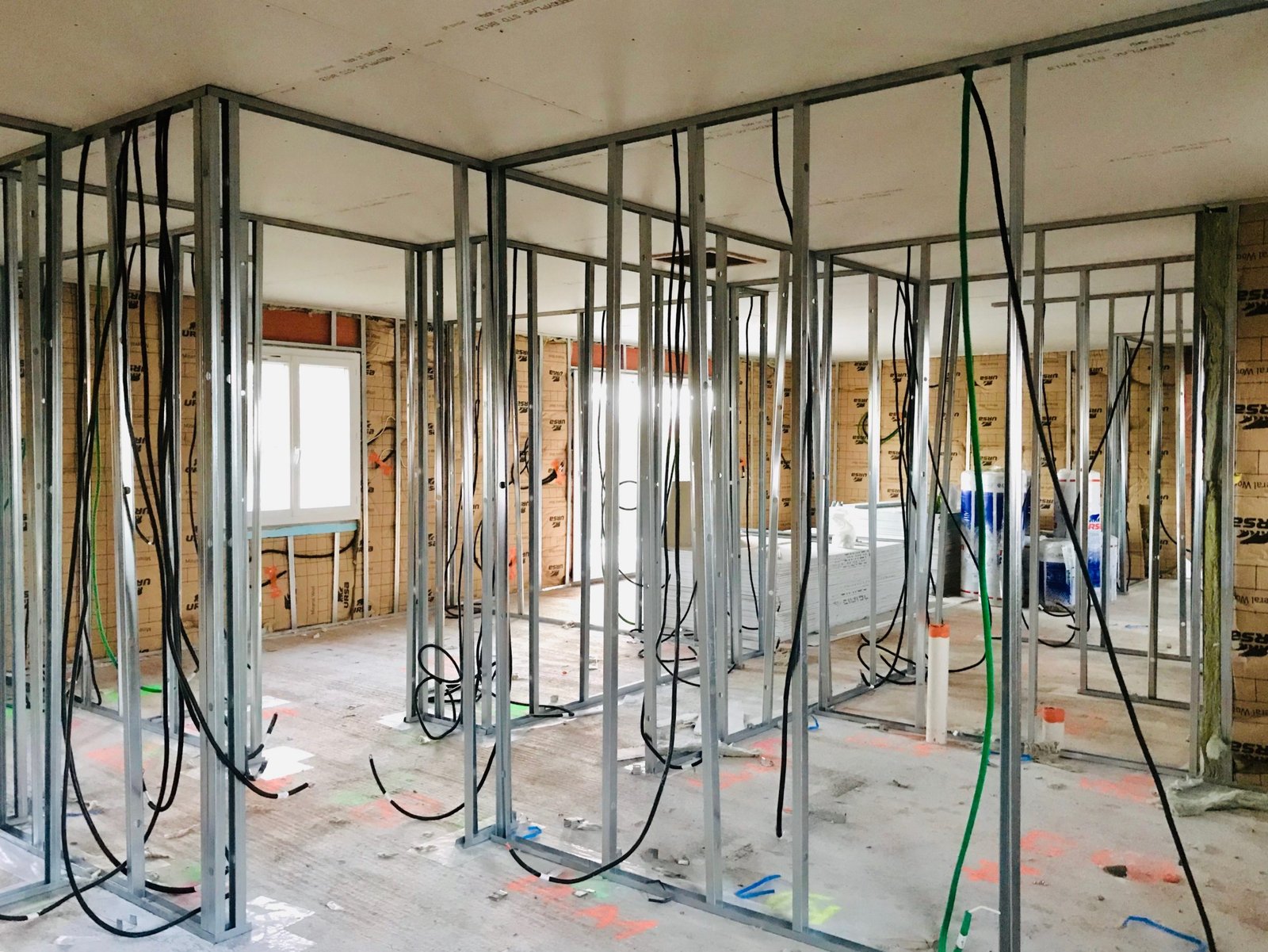 Chantier de construction montrant ossature métallique et câblage électrique