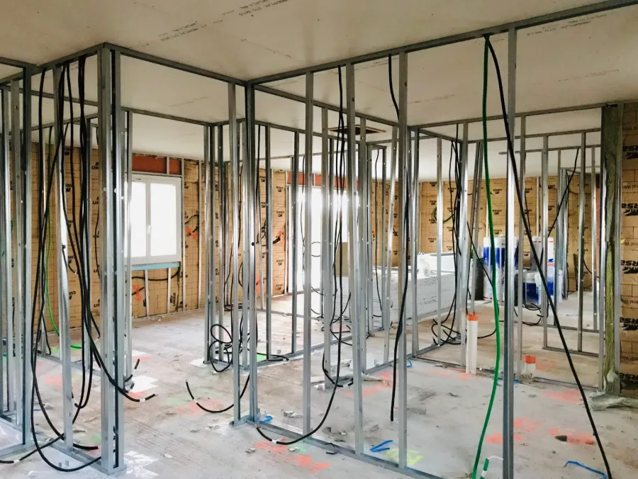 Chantier de construction montrant ossature métallique et câblage électrique