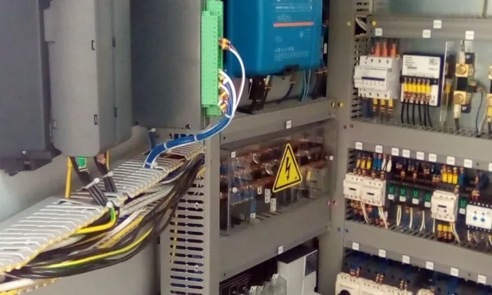 Armoire électrique industrielle avec câblage multicolore et avertissement haute tension